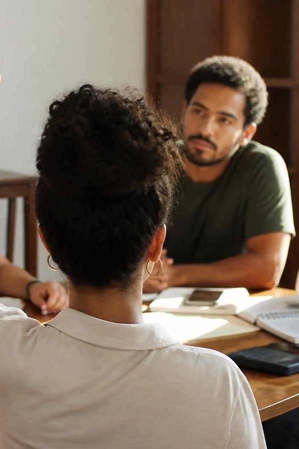 Dupla preparando a rodada com cadernos abertos e canetas marcadoras sobre a mesa